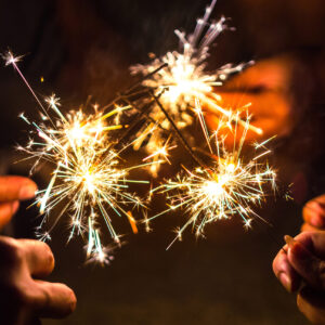 Hands of people holding sparkler, Bright festive Christmas sparkler.